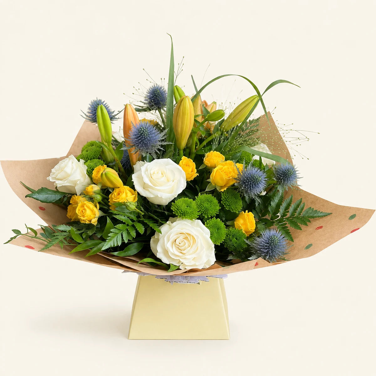 Side view of The Pistachio bouquet with yellow roses, white roses, lilies and blue thistles