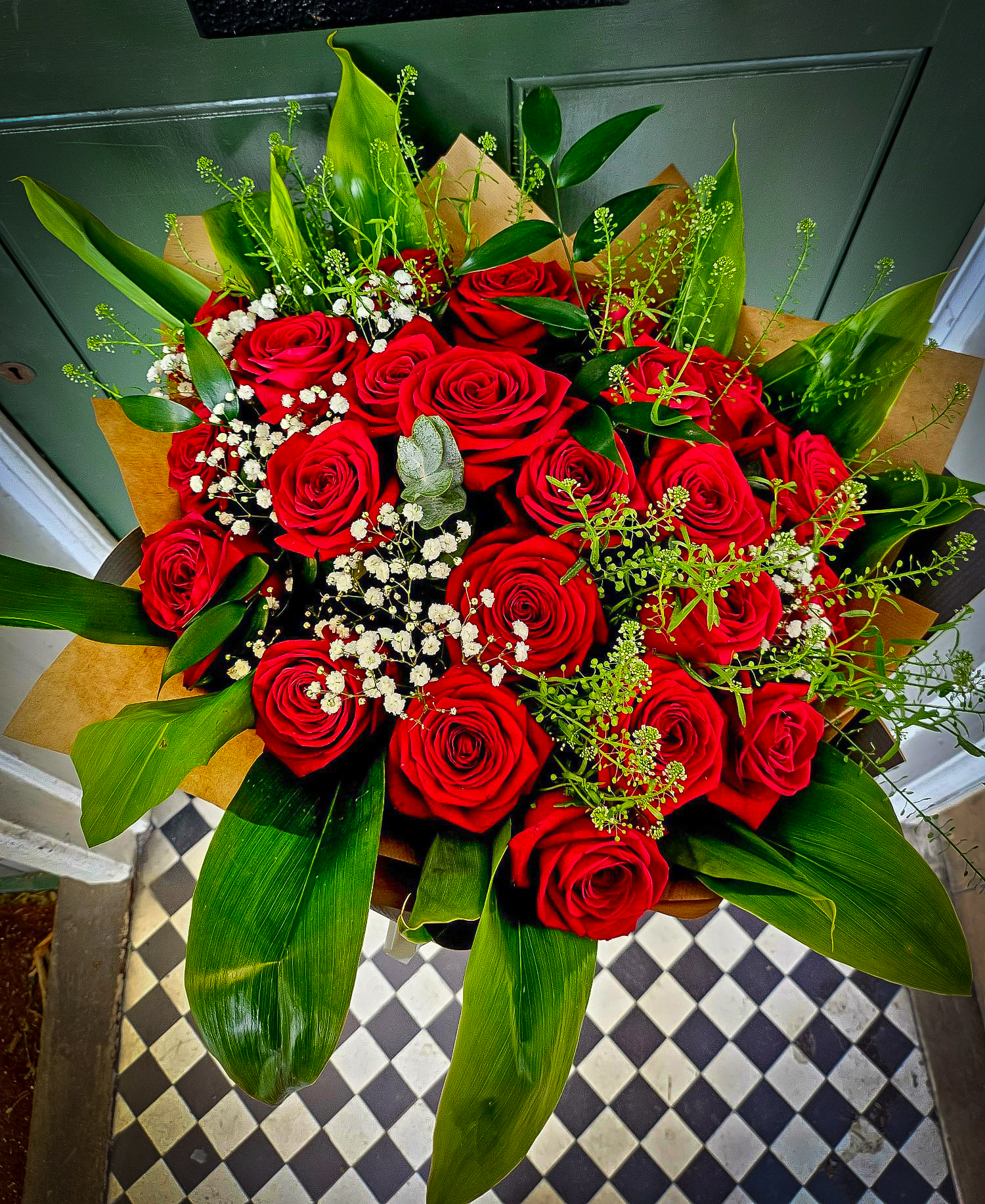 Twenty-four red Naomi roses with gypsophila and greenery
