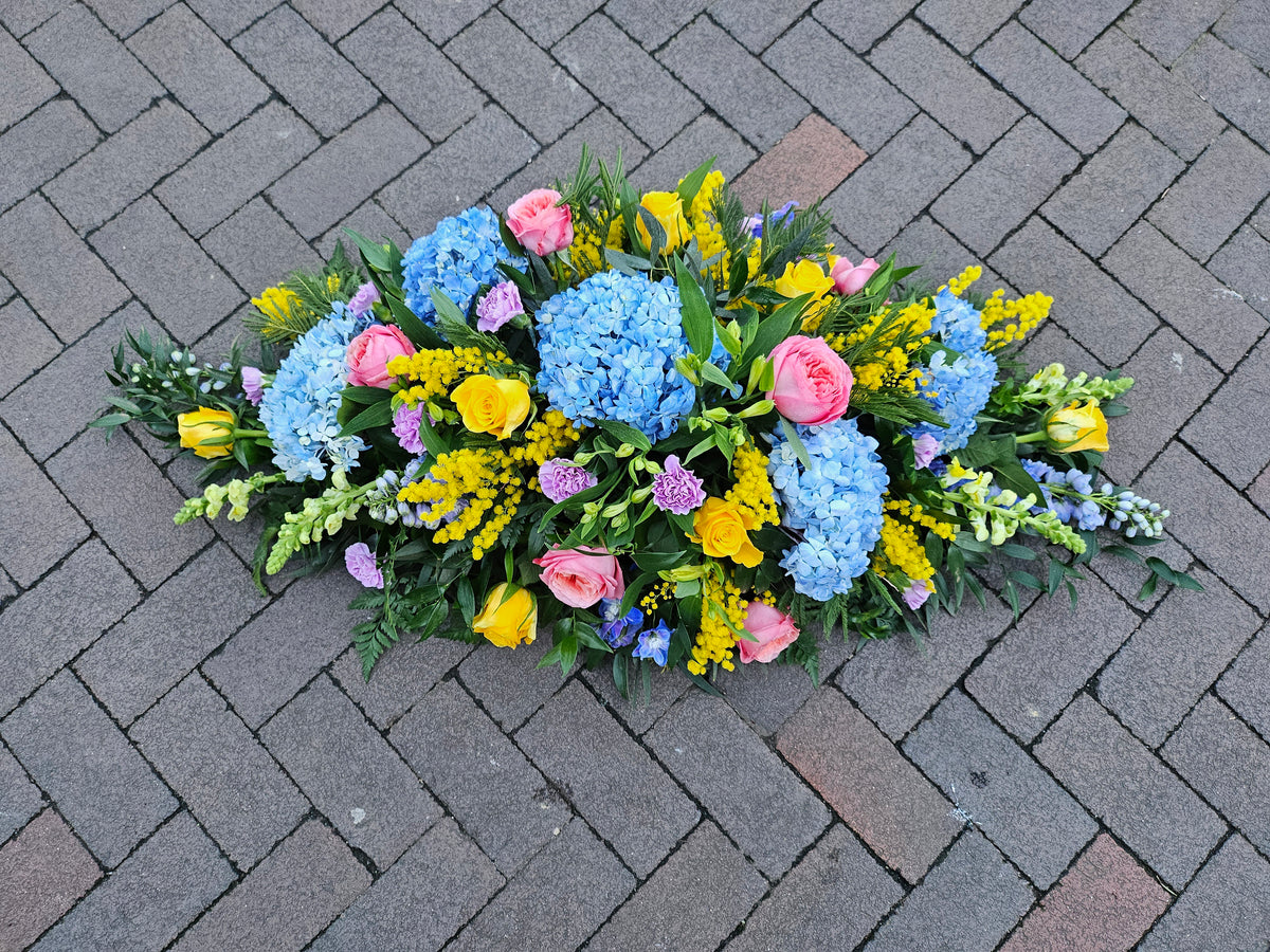 Beautiful Brights with Blue funeral casket spray, view 1