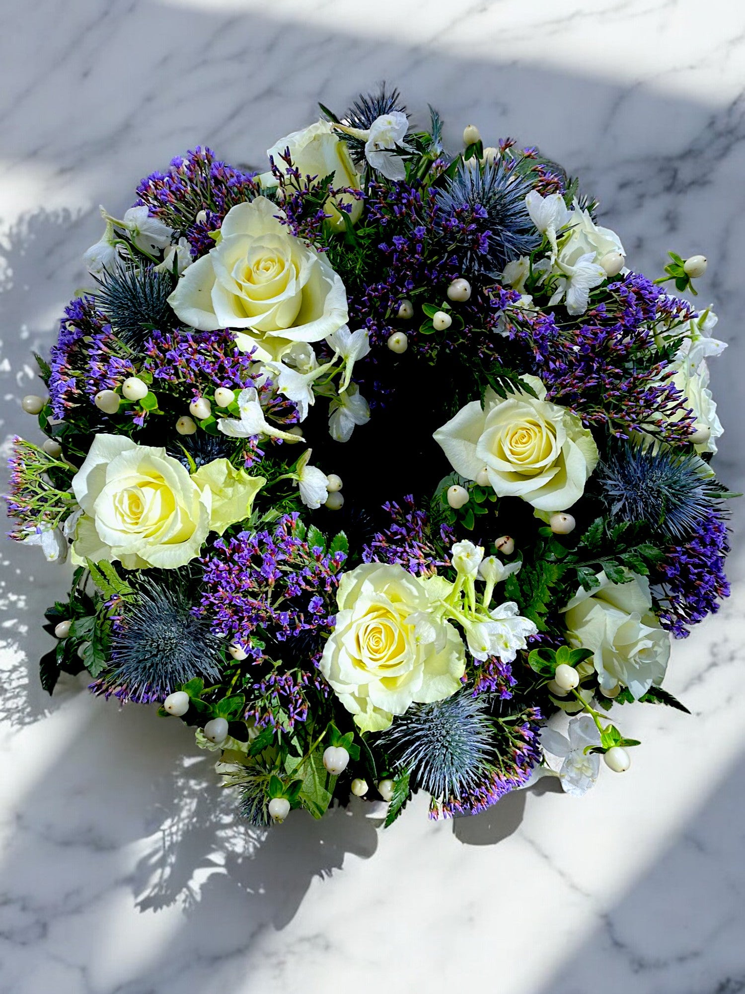 Cream and thistle wreath on marble table