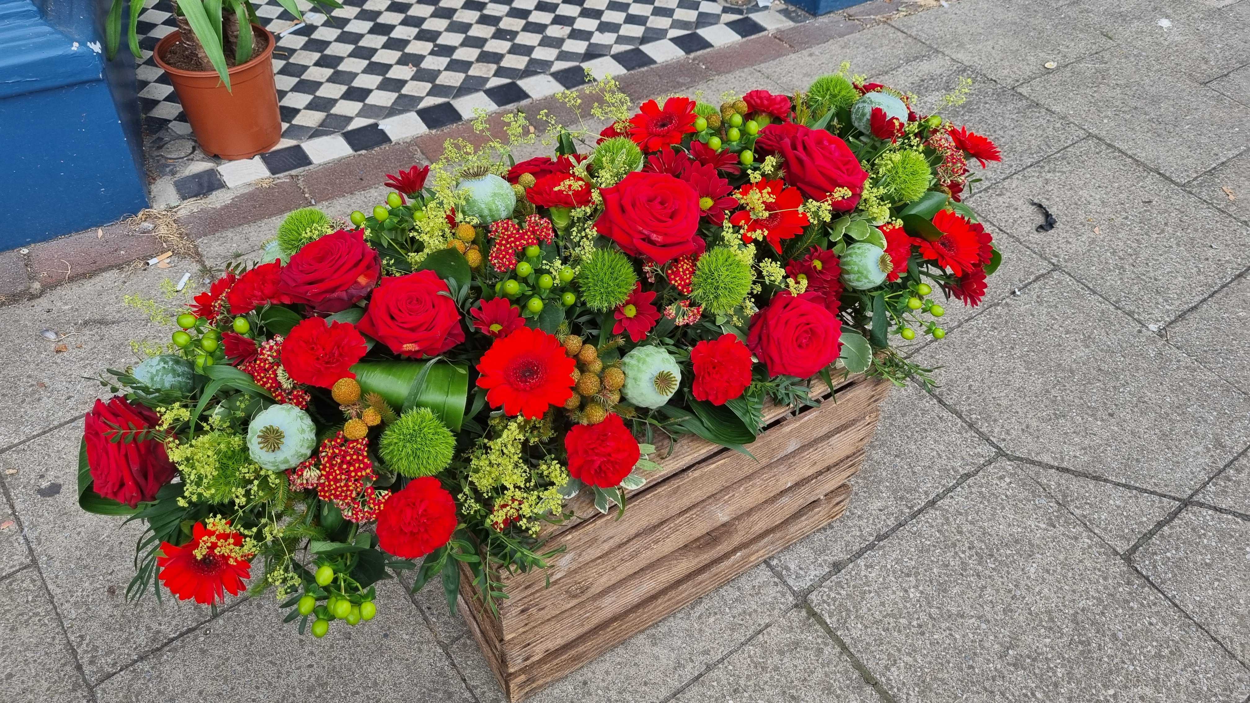 red roses with green funeral flowers