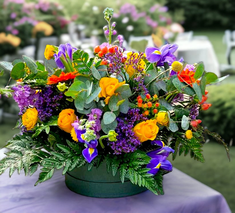 Sunflower hatbox with yellow roses, purple lisianthus and eucalyptus in a lilac box