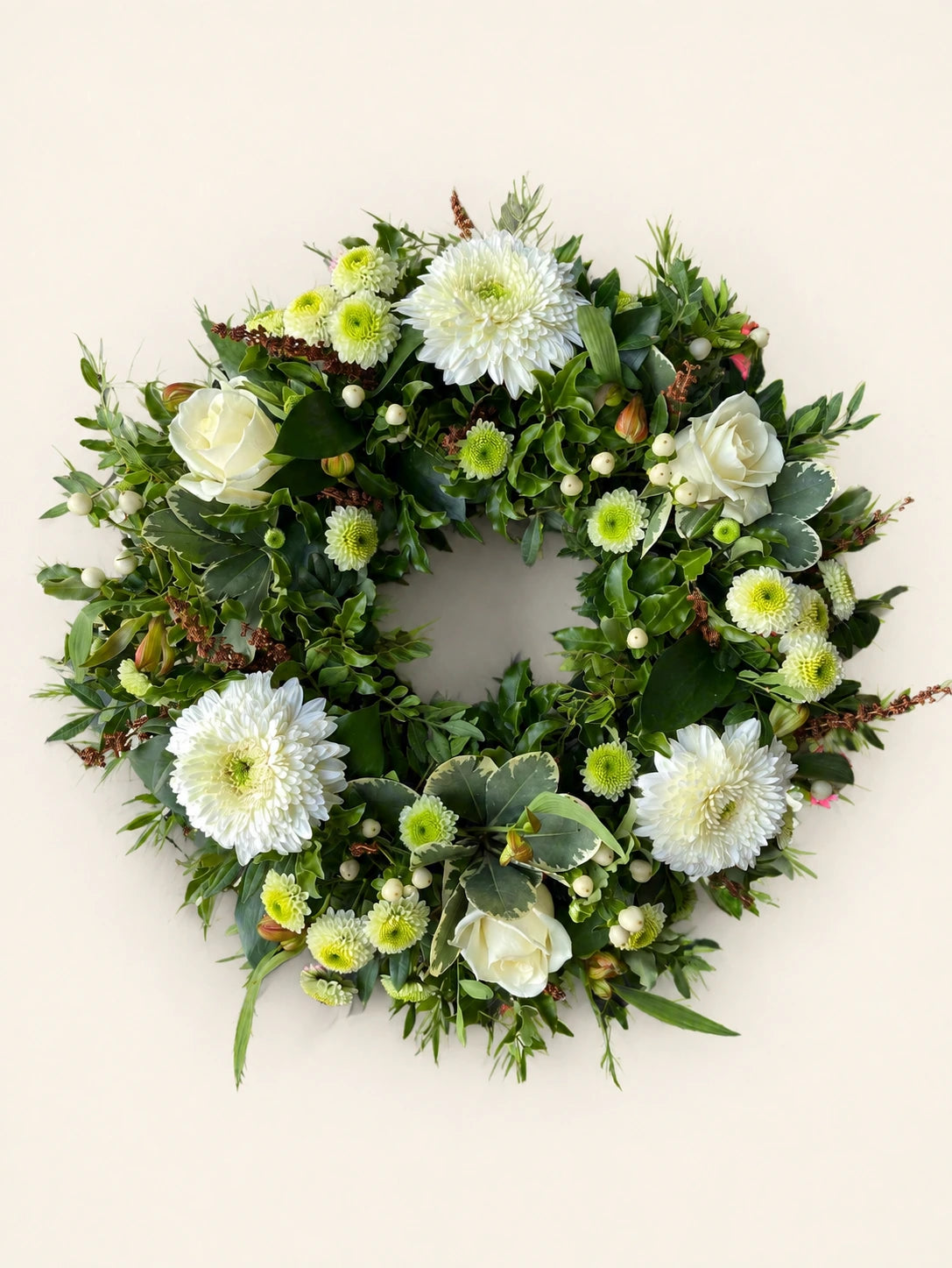 Natural funeral wreath with white chrysanthemums, pale green flowers, seed heads and mixed foliage