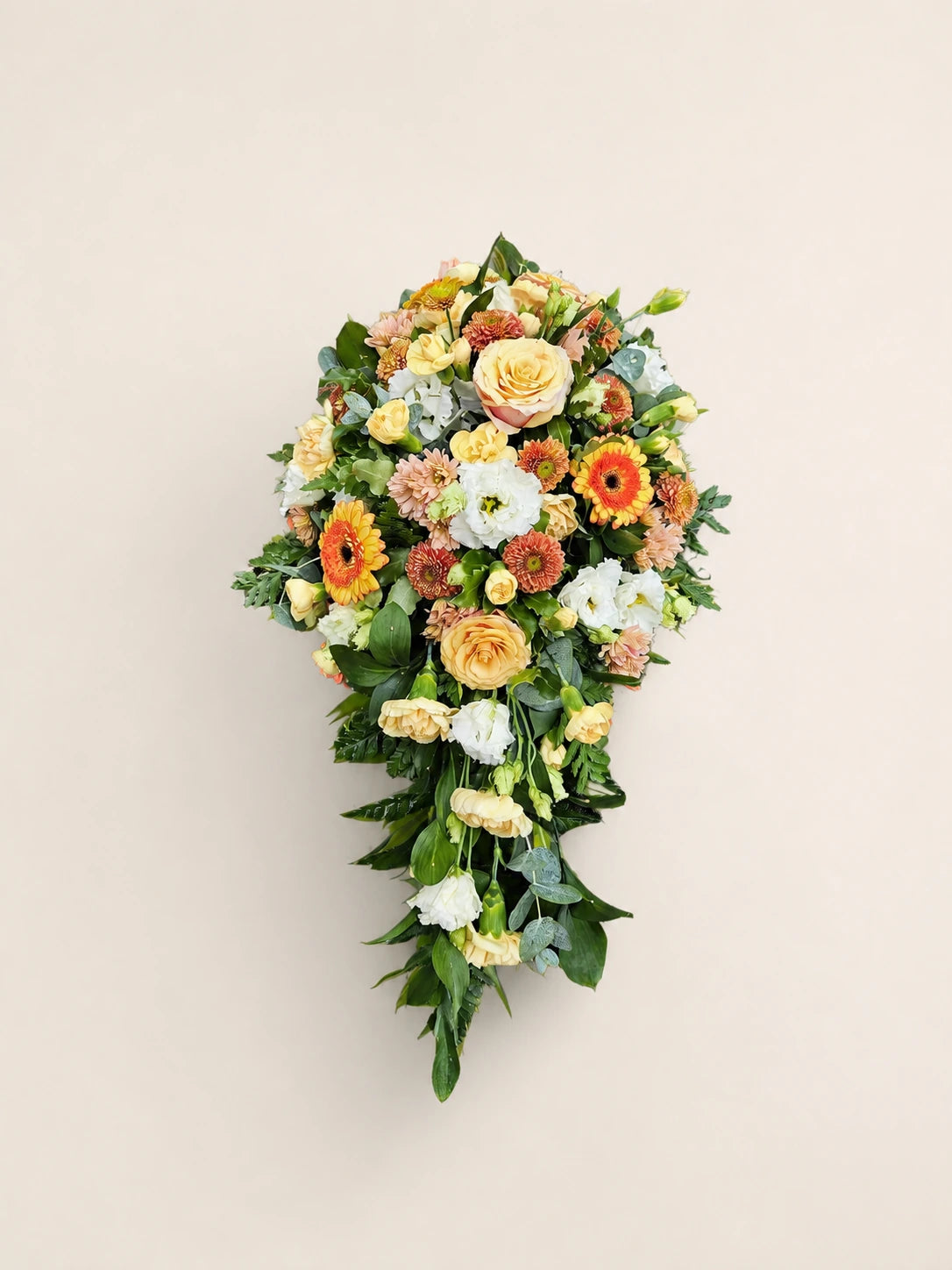 Single-ended funeral spray with peach roses, orange gerberas, cream flowers and green foliage