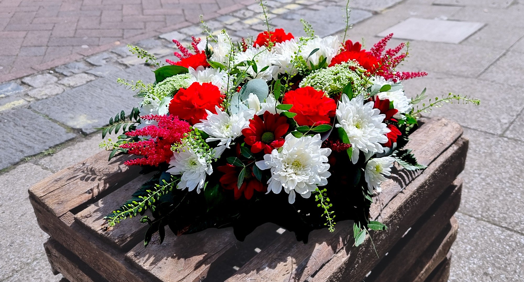 Red and white wreath on wooden crate