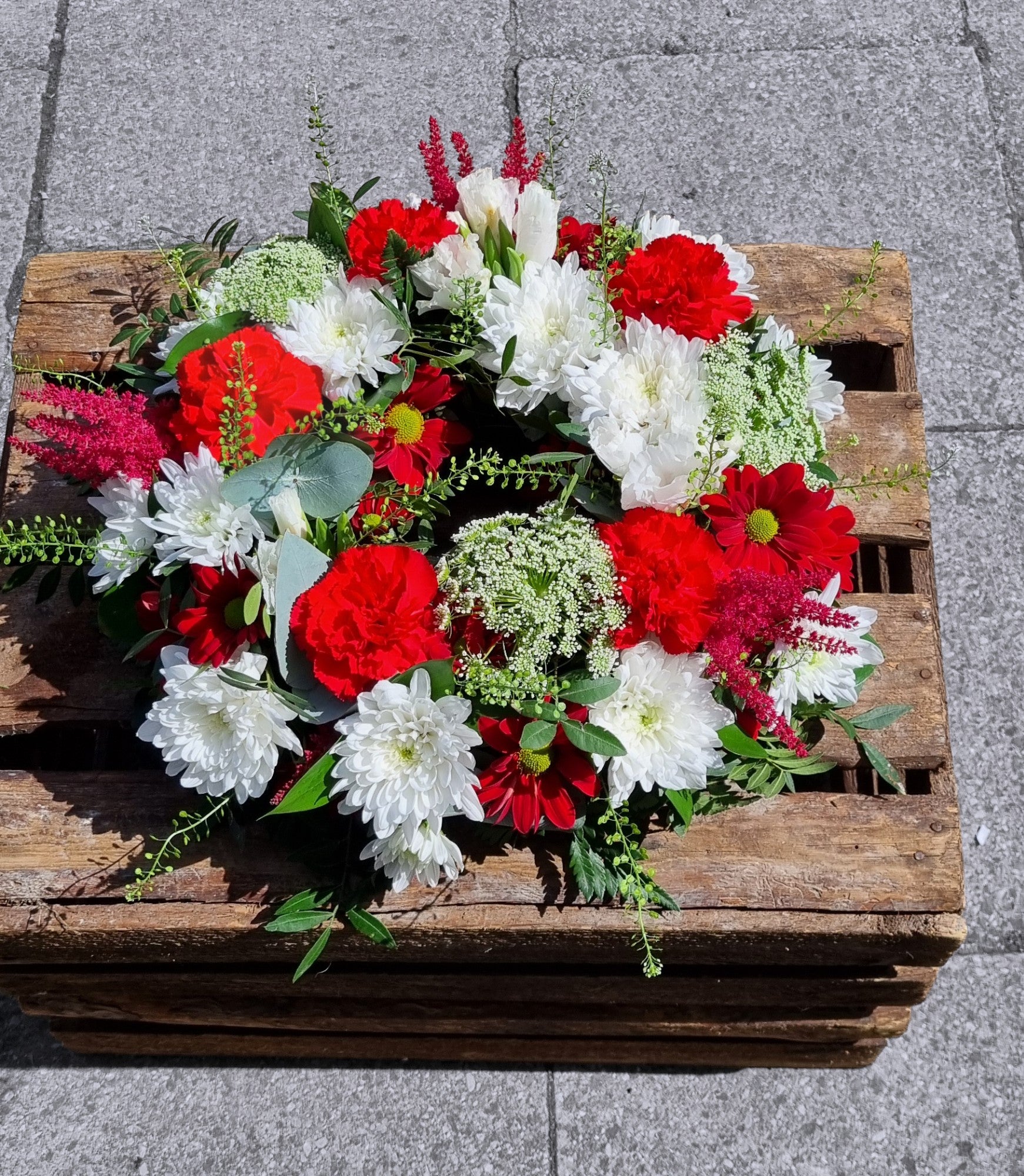 Red and White Wreath on the wooden crate