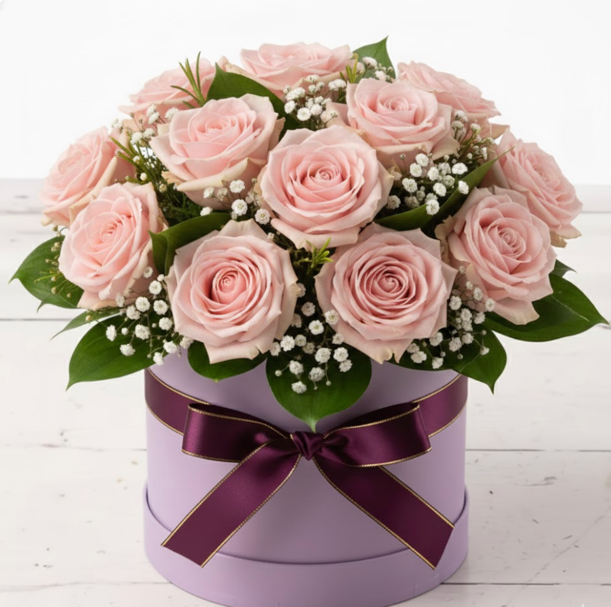 Bouquet of pink roses in a purple box with a purple ribbon on a white wooden surface