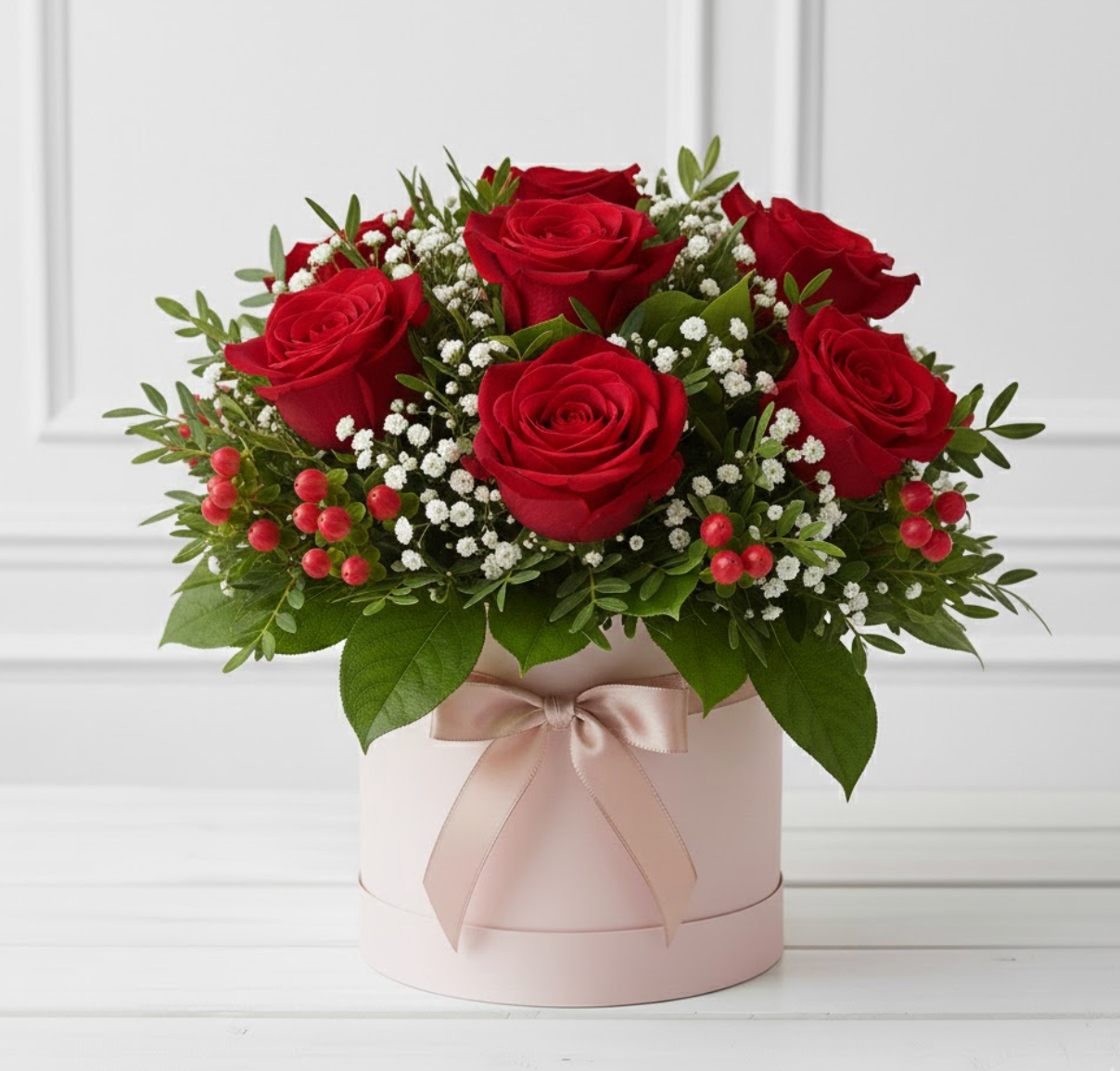 Bouquet of red roses with greenery in a pink box on a white background