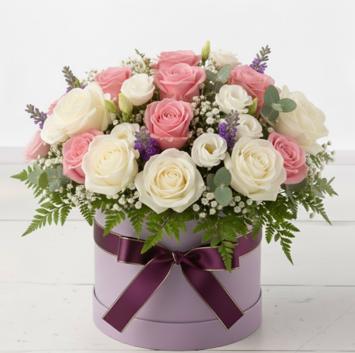Floral arrangement in a purple box with a purple ribbon on a white background
