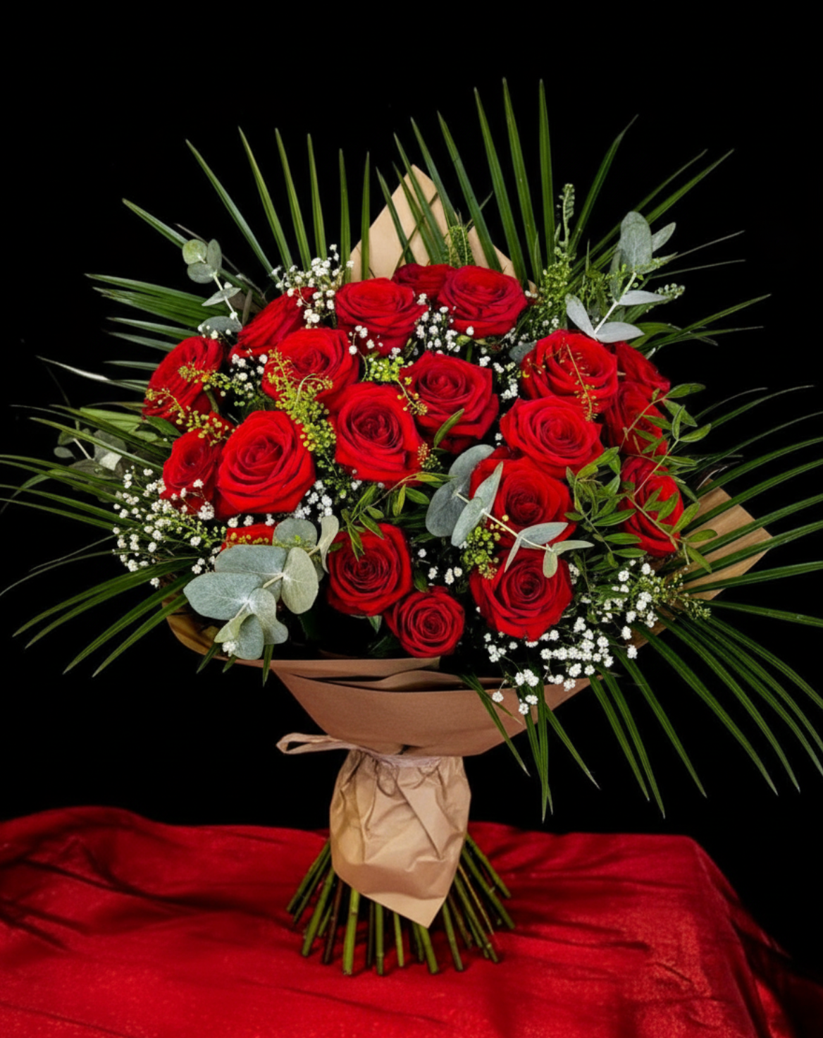 Bouquet of red roses with greenery on a black background