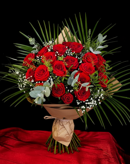 Bouquet of red roses with greenery on a black background