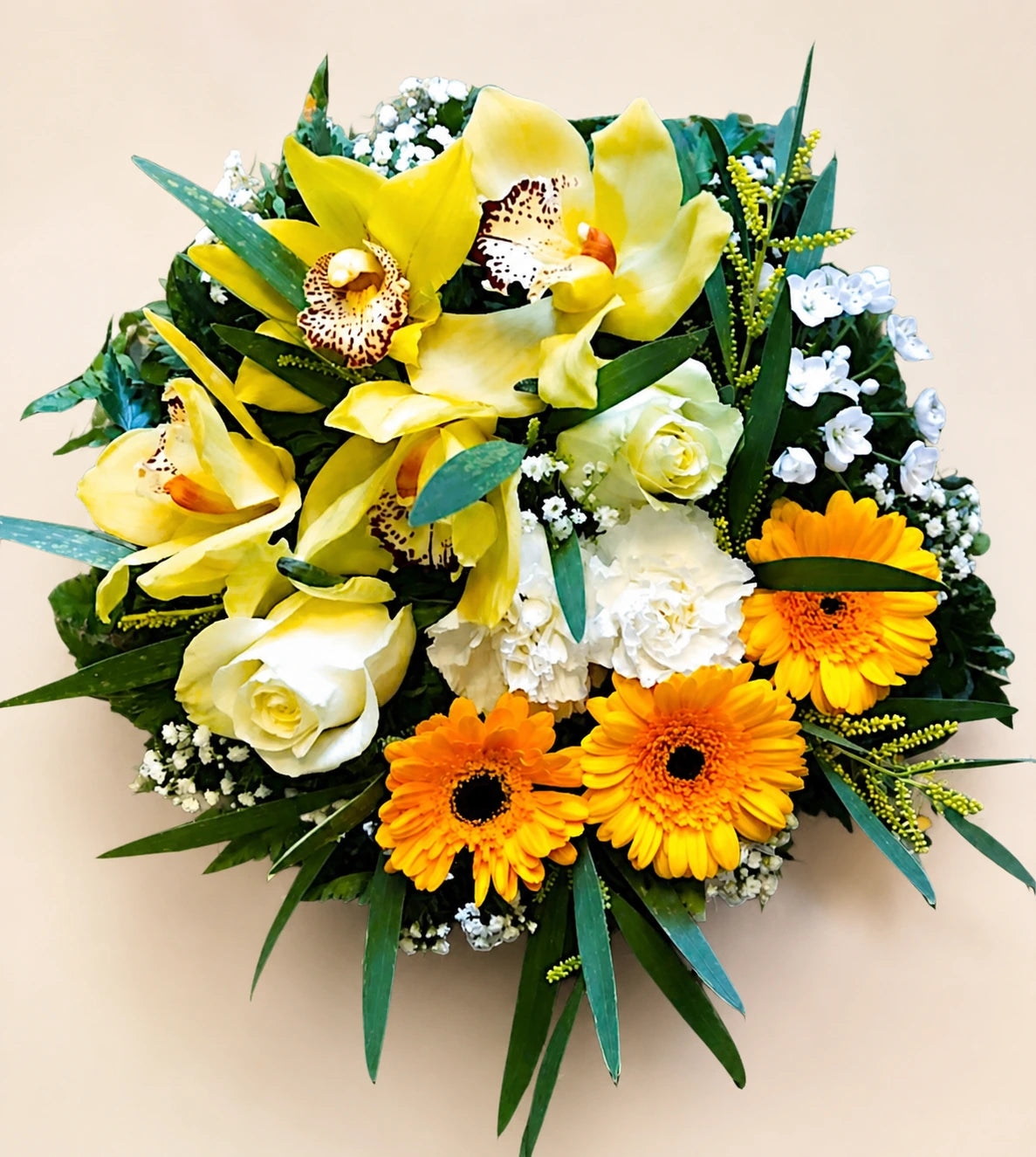 Tropical funeral posy with yellow orchids, orange gerberas, cream roses and dark green leaves