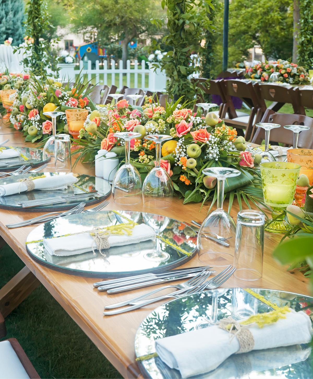Long wedding reception table styled with colourful floral arrangements and place settings.