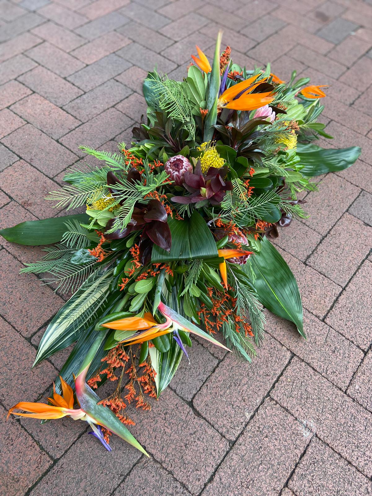 casket top with strelitzia and greens