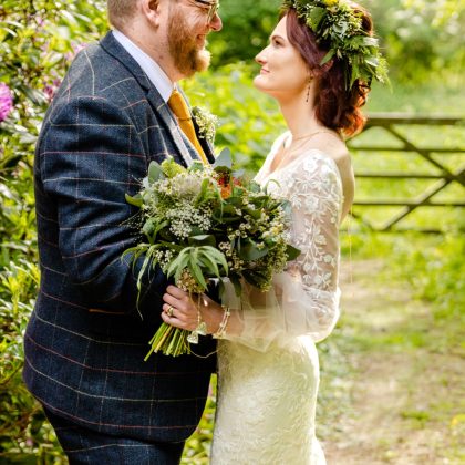 Rachel and Brian together outdoors on their wedding day, with a natural bridal bouquet.