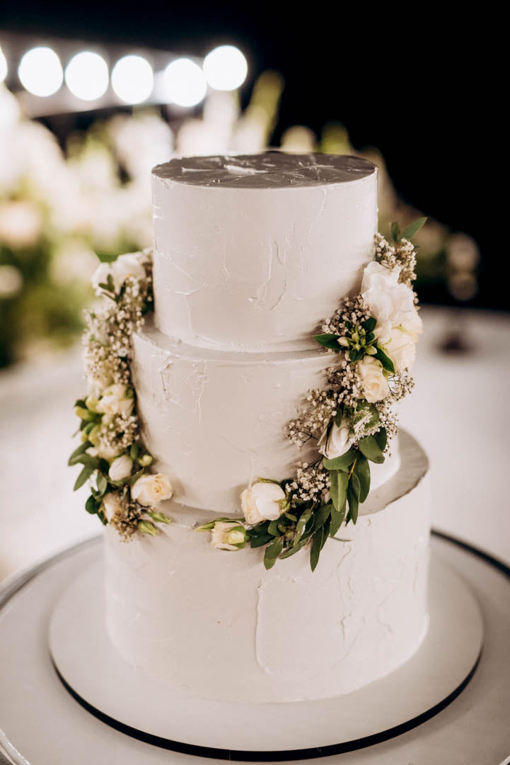 Wedding cake decorated with flowers as part of a reception display.
