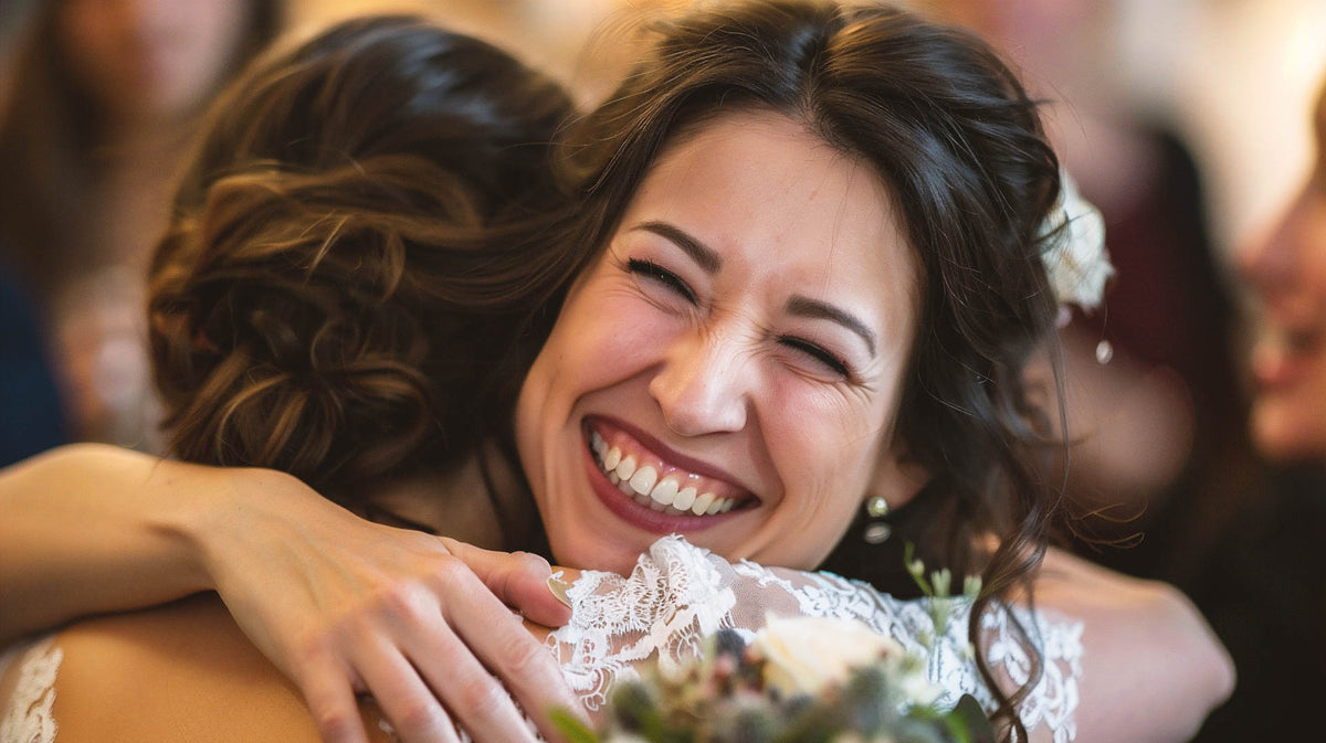 Bride embracing a wedding guest in a candid wedding-day photograph.