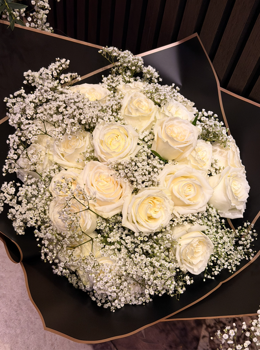 Rounded bouquet of white roses prepared for a romantic proposal.
