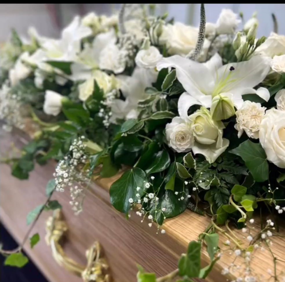 white and green flowers on casket